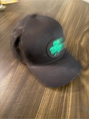 Hoka Black Trucker Hat with Green Shamrock Patch